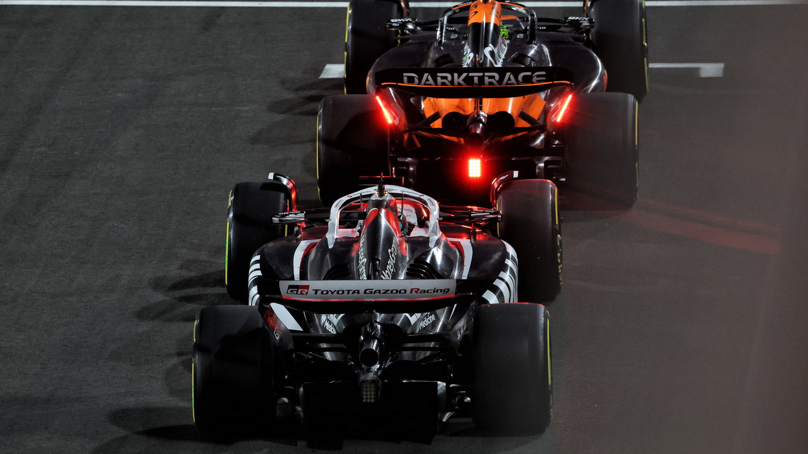 McLaren and Haas leave the pit lane 