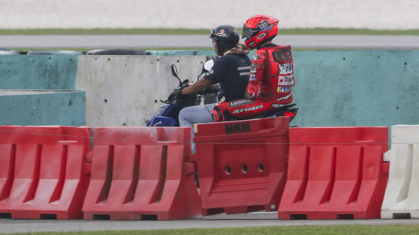 Marc Marquez riding back to the paddock on a scooter after crashing, 2025 MotoGP Sepang Test. Credit: Gold and Goose.