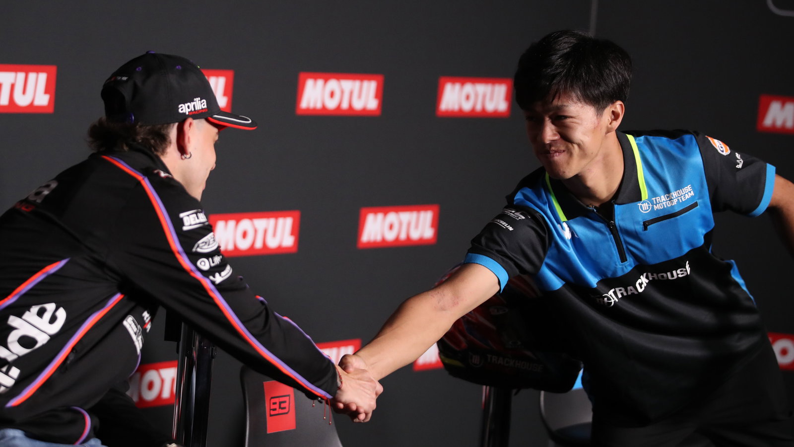 Ai Ogura and Marco Bezzecchi shake hands during the 2025 MotoGP Japanese Grand Prix pre-event press conference. Credit: Gold and Goose.