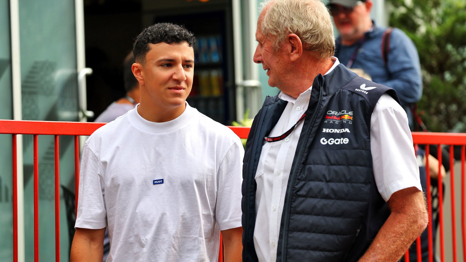 Isack Hadjar chats to Red Bull's Helmut Marko in the Baku paddock
