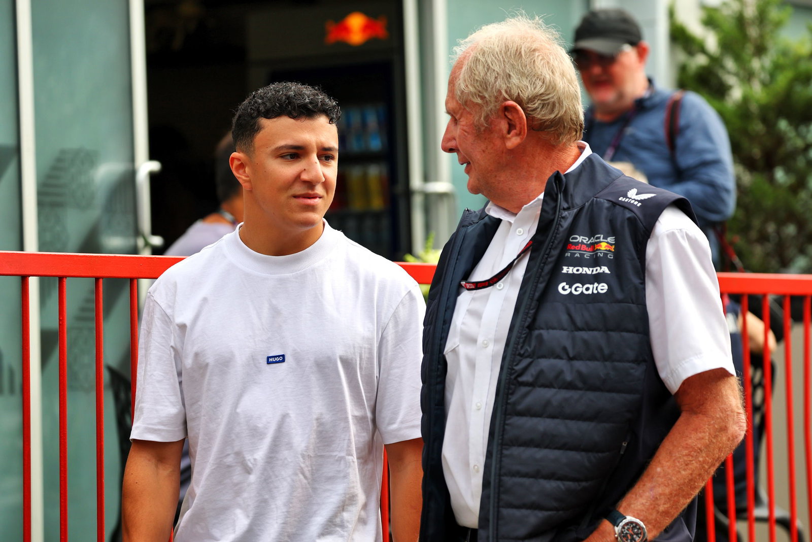 Isack Hadjar chats to Red Bull's Helmut Marko in the Baku paddock