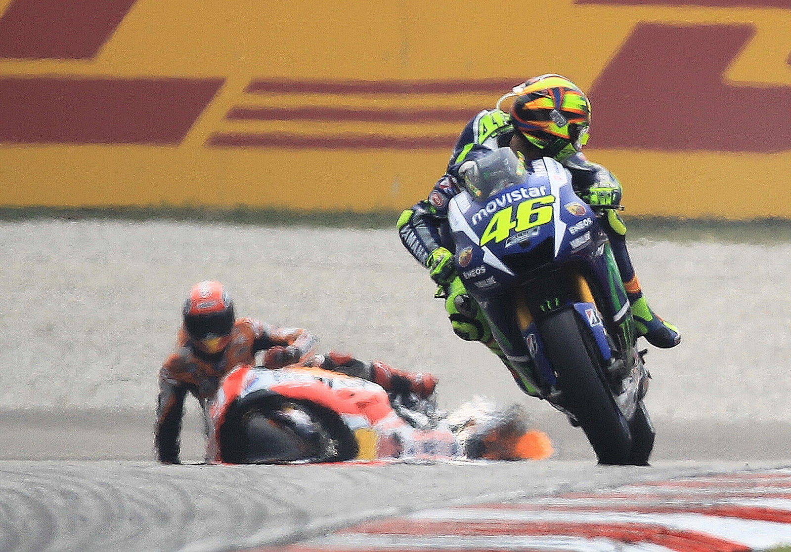 Valentino Rossi looks back at Marc Marquez on the ground, 2015 Malaysian MotoGP