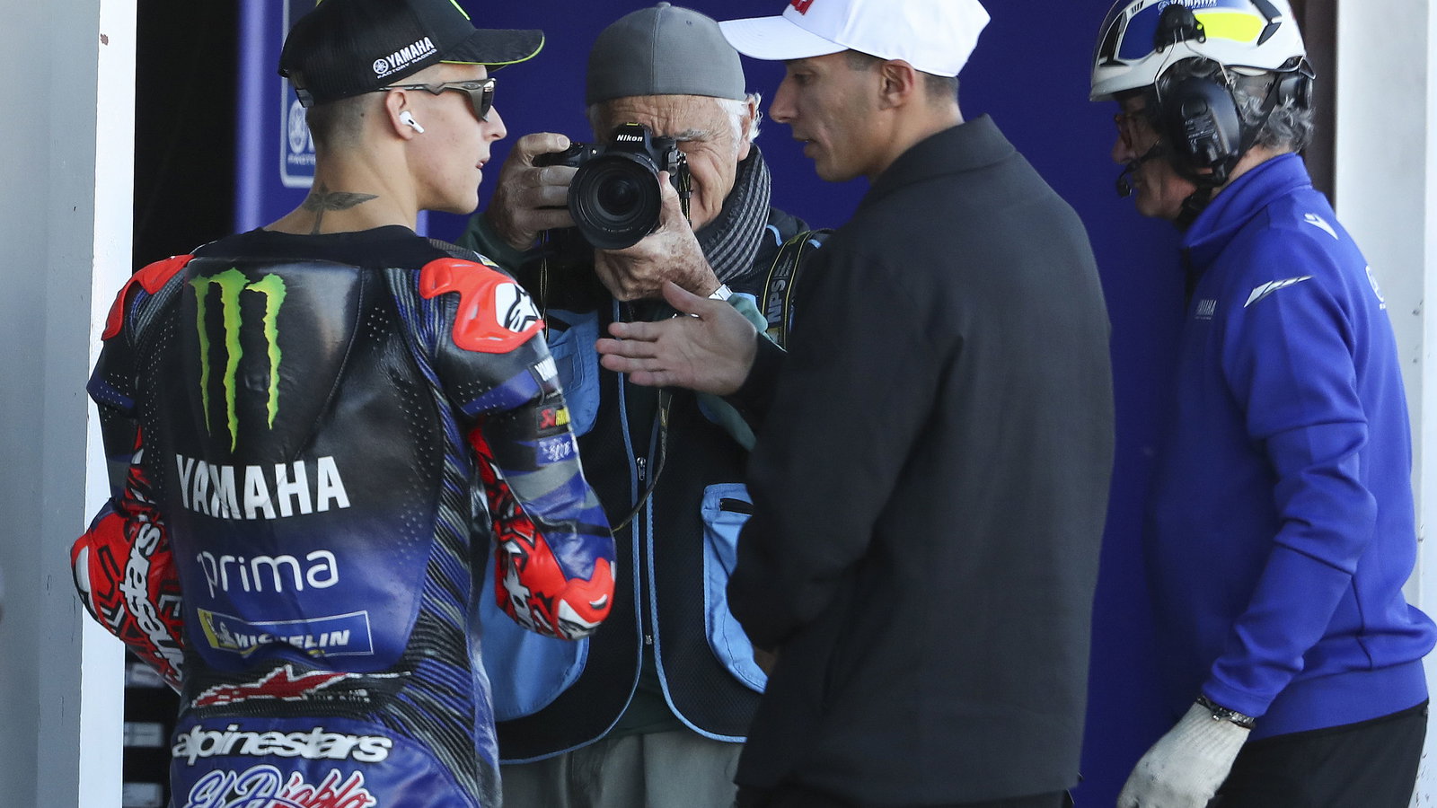 Fabio Quartararo speaks with Toprak Razgatlioglu, 2025 MotoGP Valencia Grand Prix, pit lane. Credit: Gold and Goose.