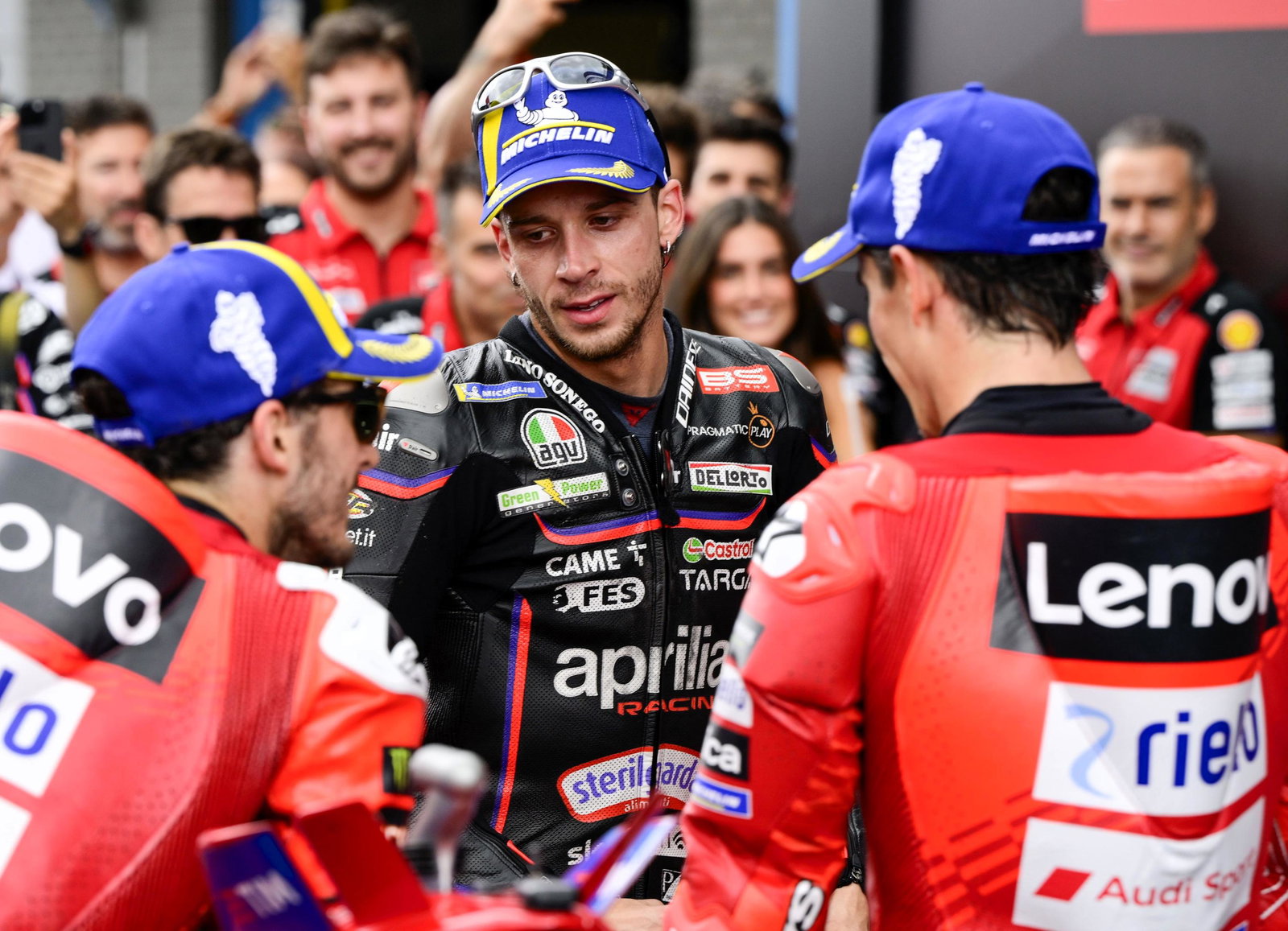 Marco Bezzecchi in parc ferme with factory Ducati riders Marc Marquez and Francesco Bagnaia.