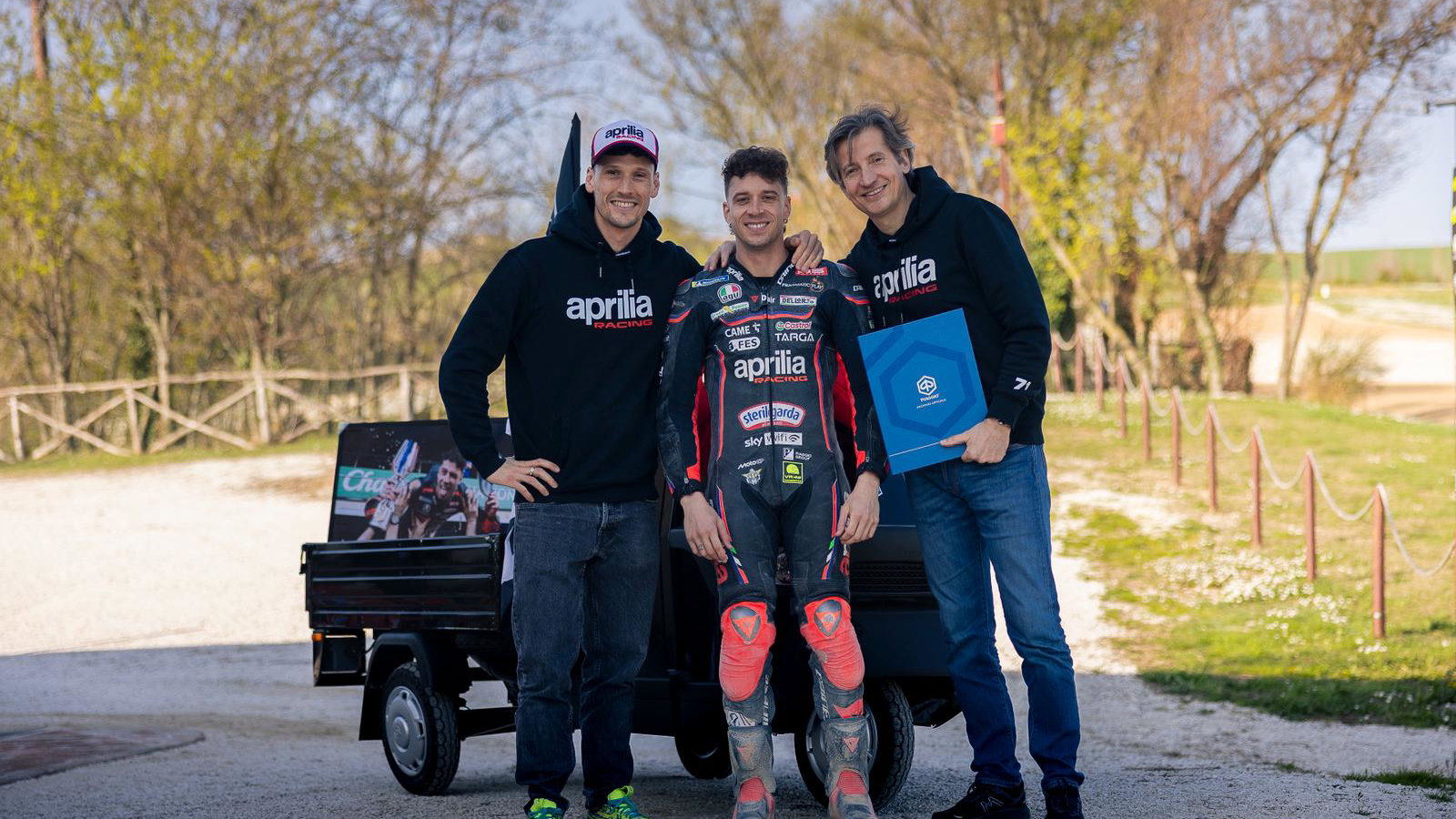 Lorenzo Savadori, Marco Bezzecchi, Massimo Rivola with Piaggio Ape. Credit: Aprilia Racing.