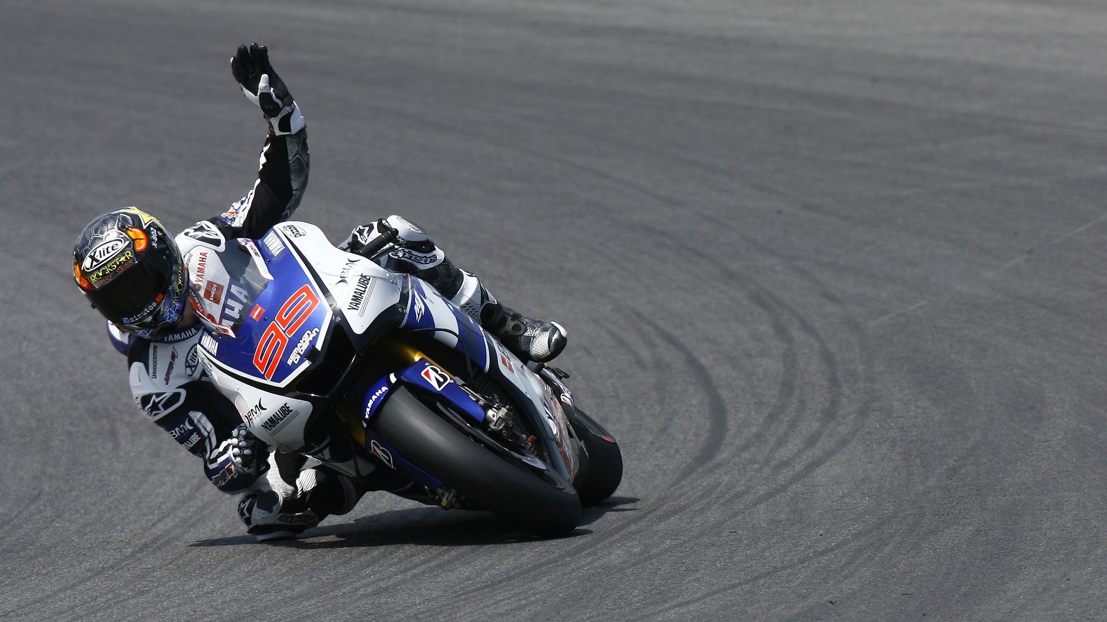 Lorenzo, waving to fans whilst still racing on last lap, Italian MotoGP 2012