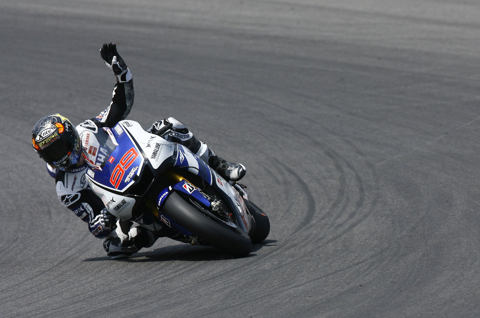 Lorenzo, waving to fans whilst still racing on last lap, Italian MotoGP 2012