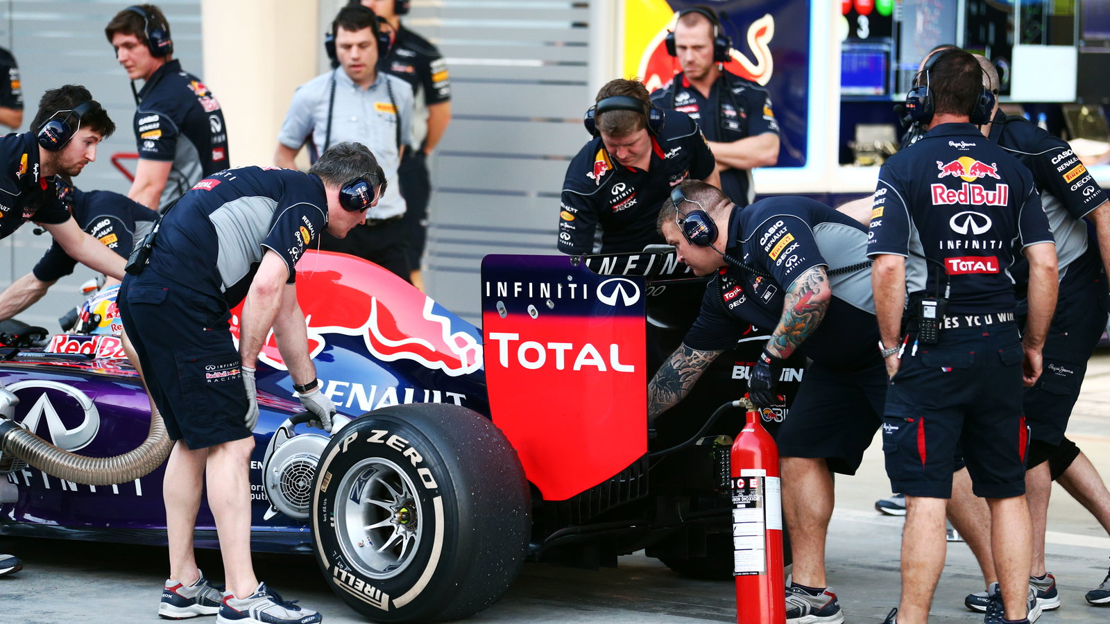 Red Bull Racing mechanic with an extinguisher at the rear of the Red Bull Racing RB10 of Daniel Ricc