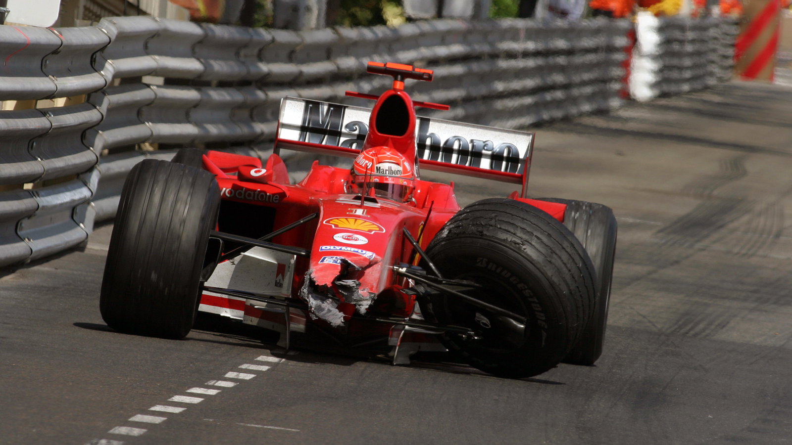 Michael Schumacher limps back to the pits in the damaged Ferrari F2004