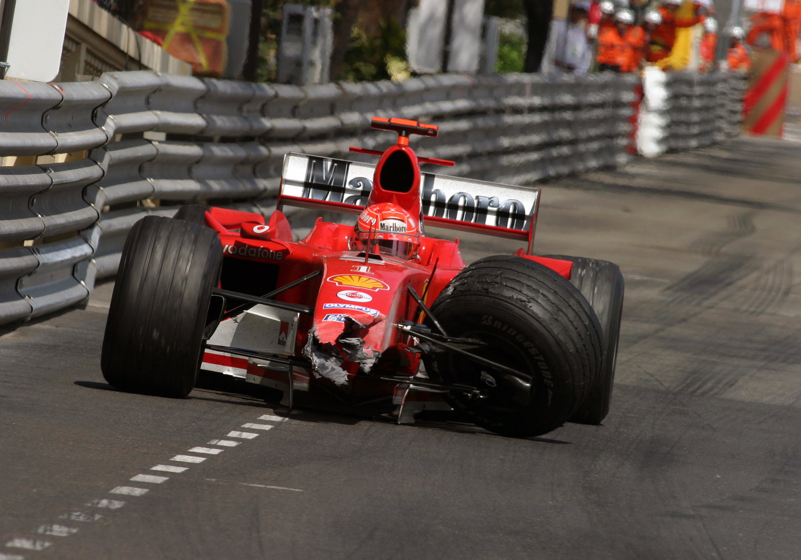 Michael Schumacher limps back to the pits in the damaged Ferrari F2004