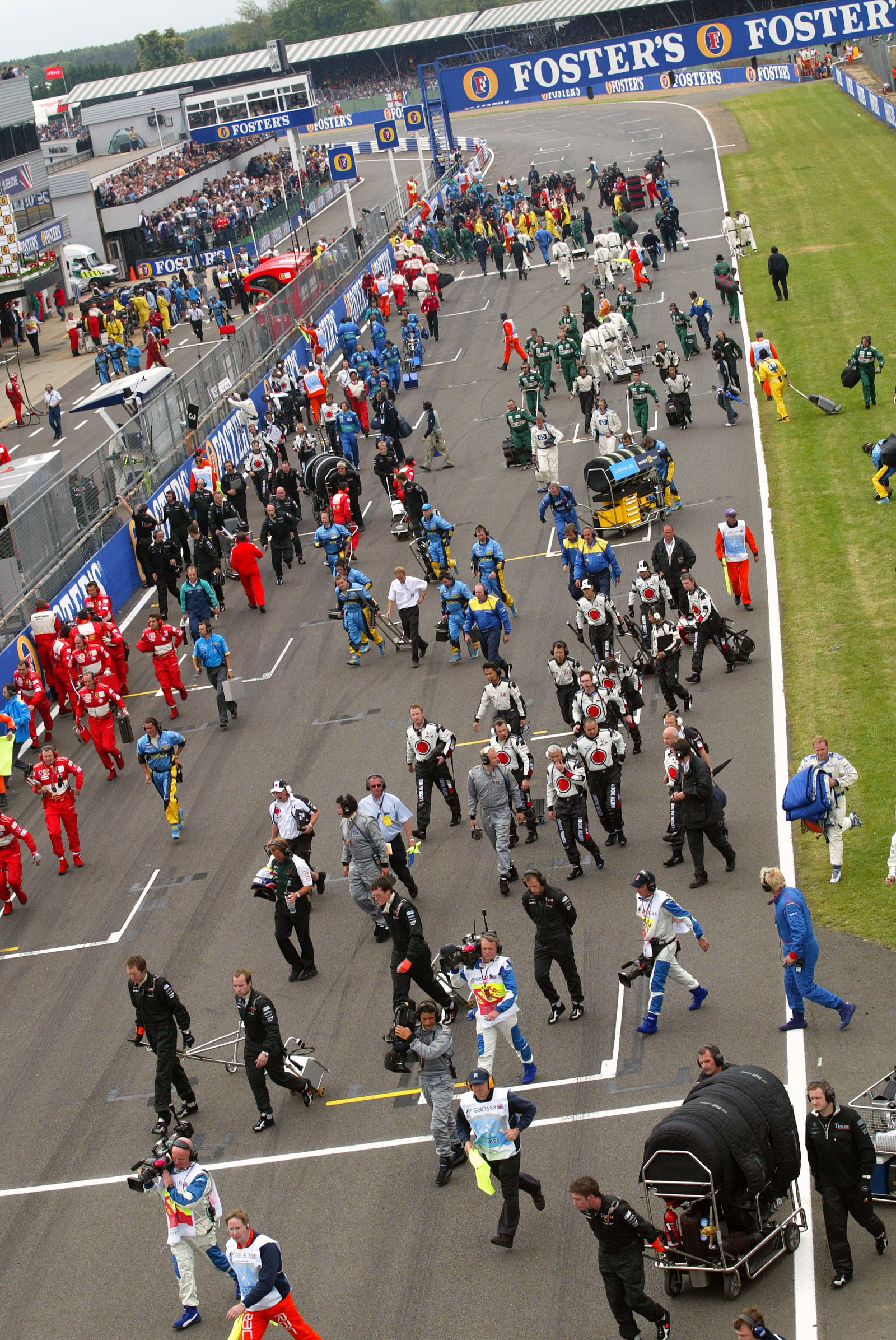 The mechanics and team pertsonnel return to the pit lane after the cars depart on their parade lap a