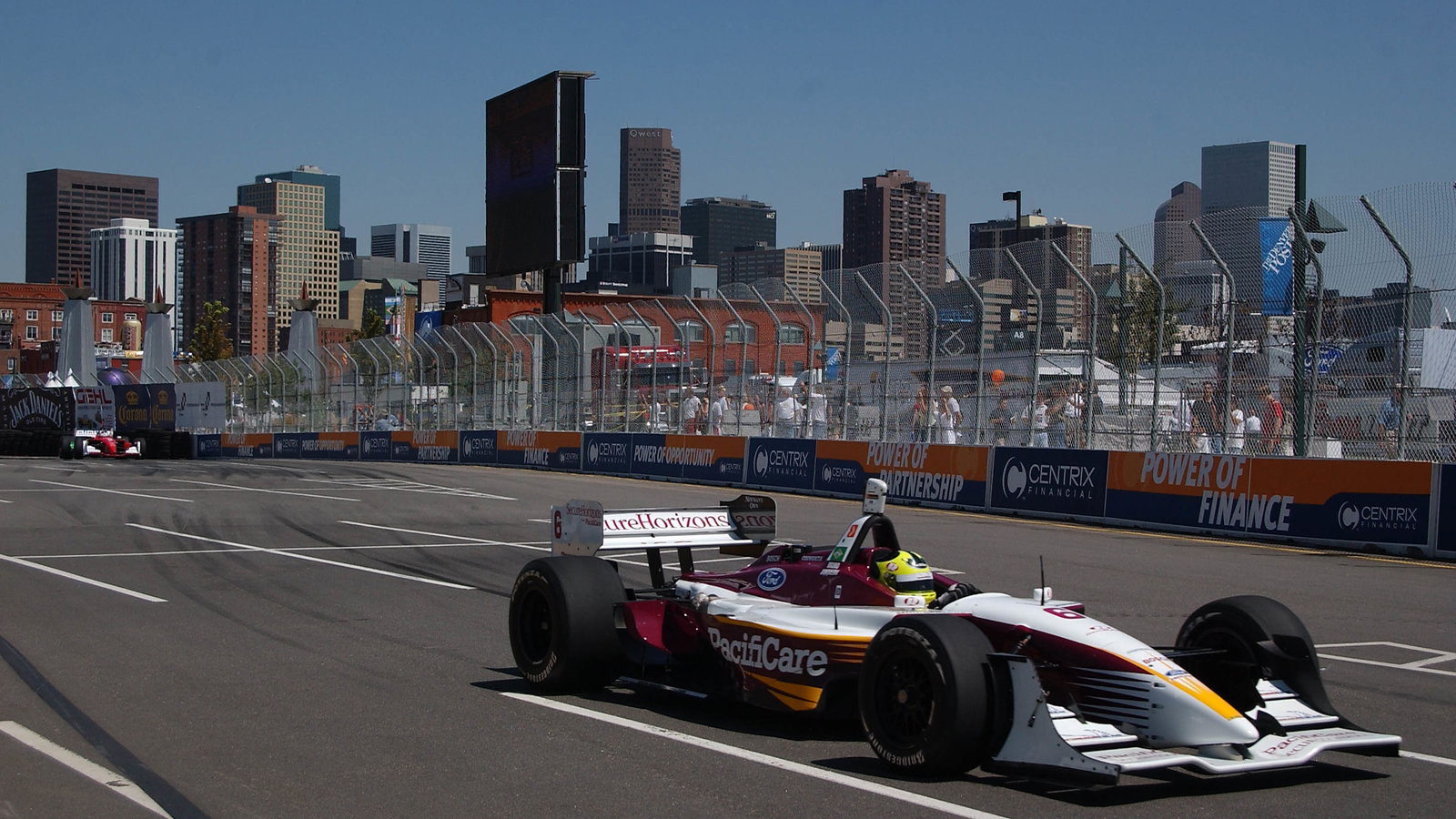 Bruno Junqueira in action with the Denver skyline behind him