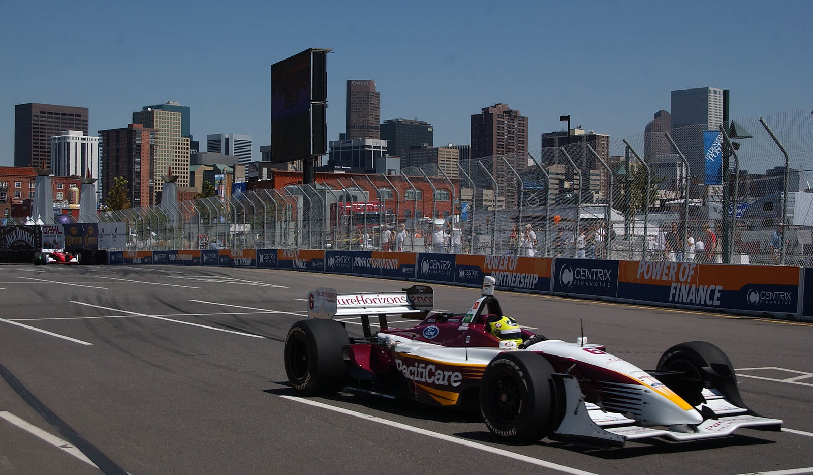 Bruno Junqueira in action with the Denver skyline behind him