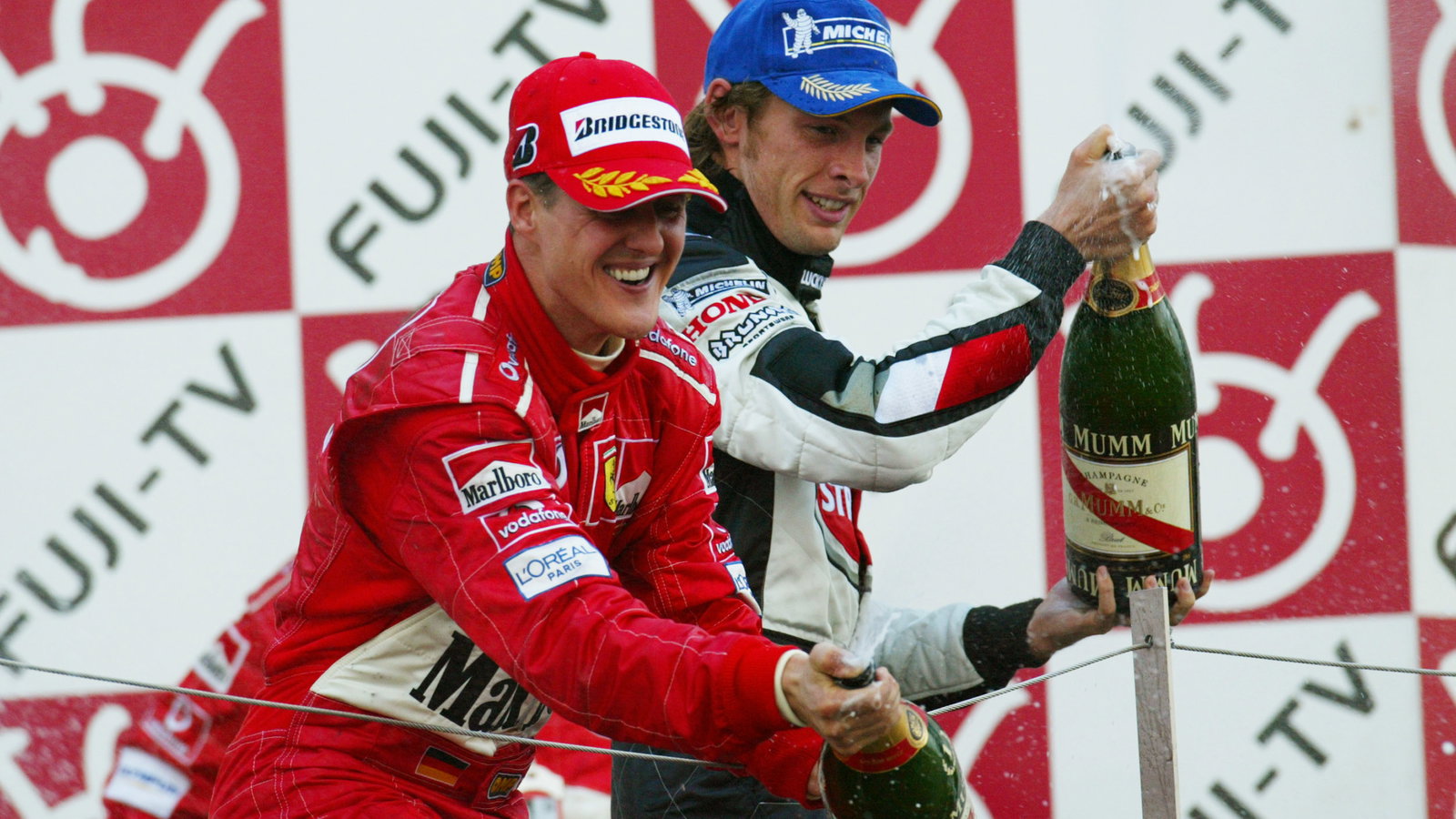 Michael Schumacher and Jenson Button celebrate after the Japanese Grand Prix