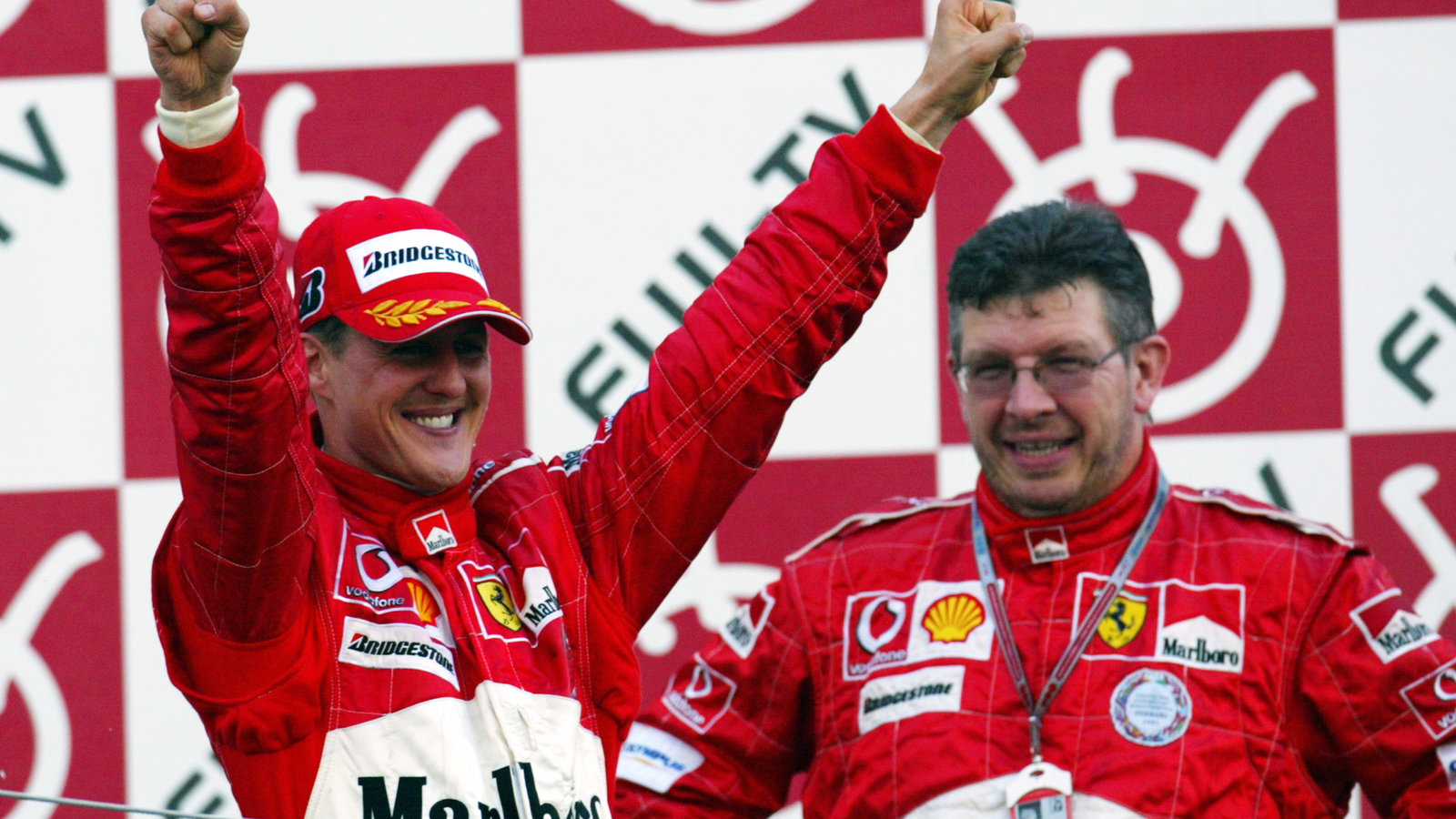 Michael Schumacher and Ross Brawn celebrate another perfect race at the 2004 Japanese Grand Prix