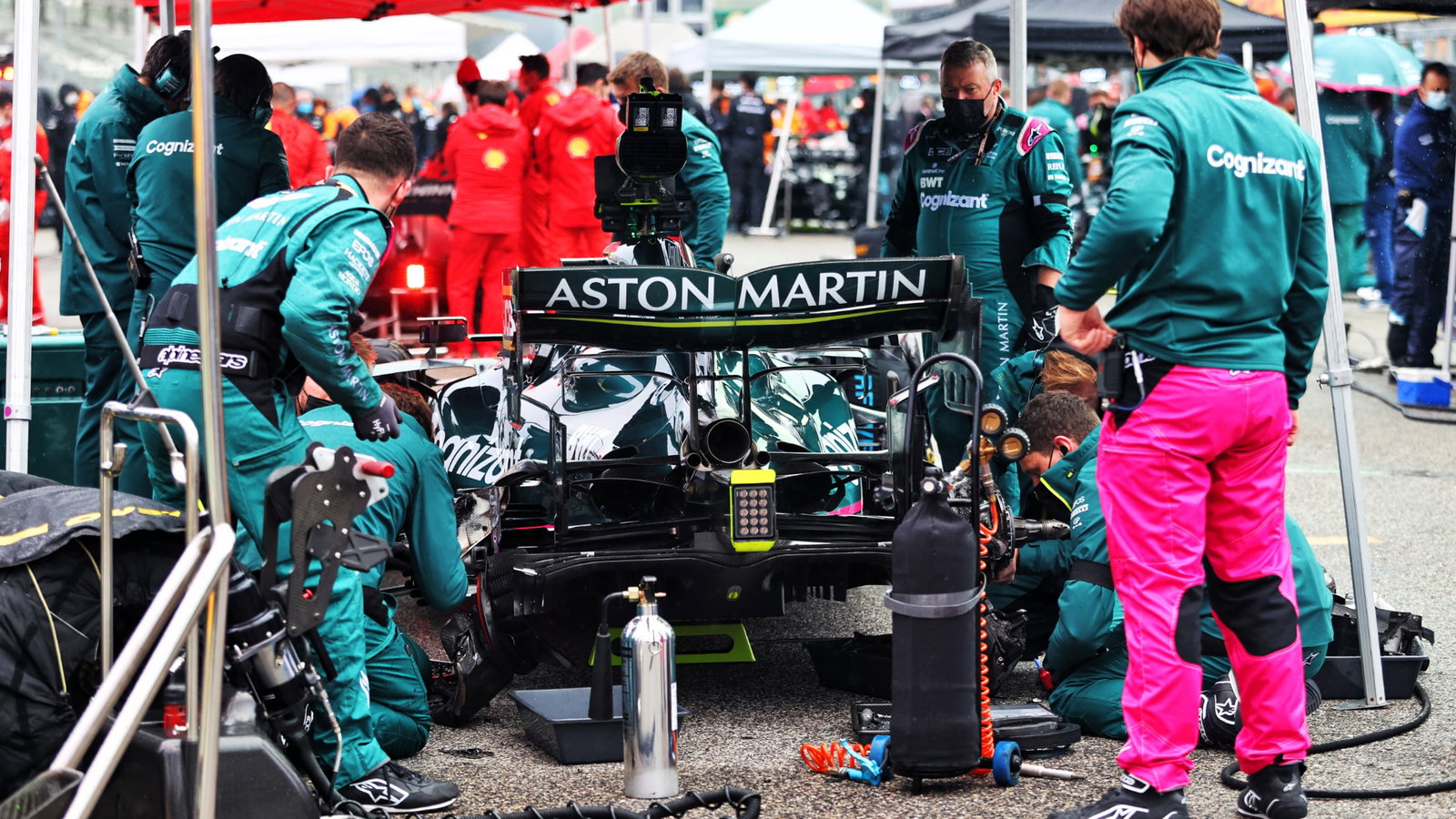 Sebastian Vettel (GER) Aston Martin F1 Team AMR21 on the grid with work being done on the rear brakes.