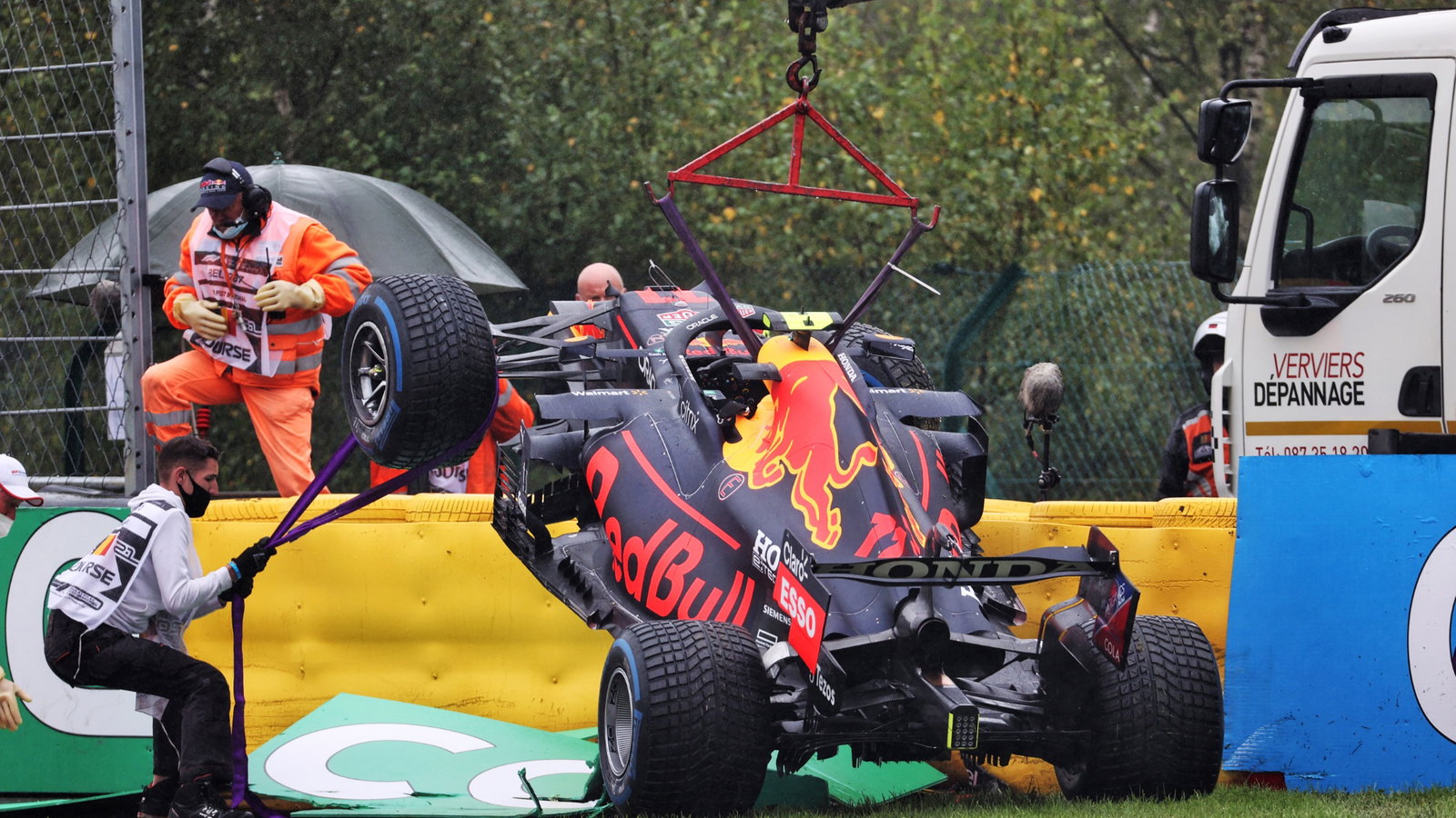 The Red Bull Racing RB16B of Sergio Perez (MEX) is craned away from the circuit after he crashed heading to the grid.