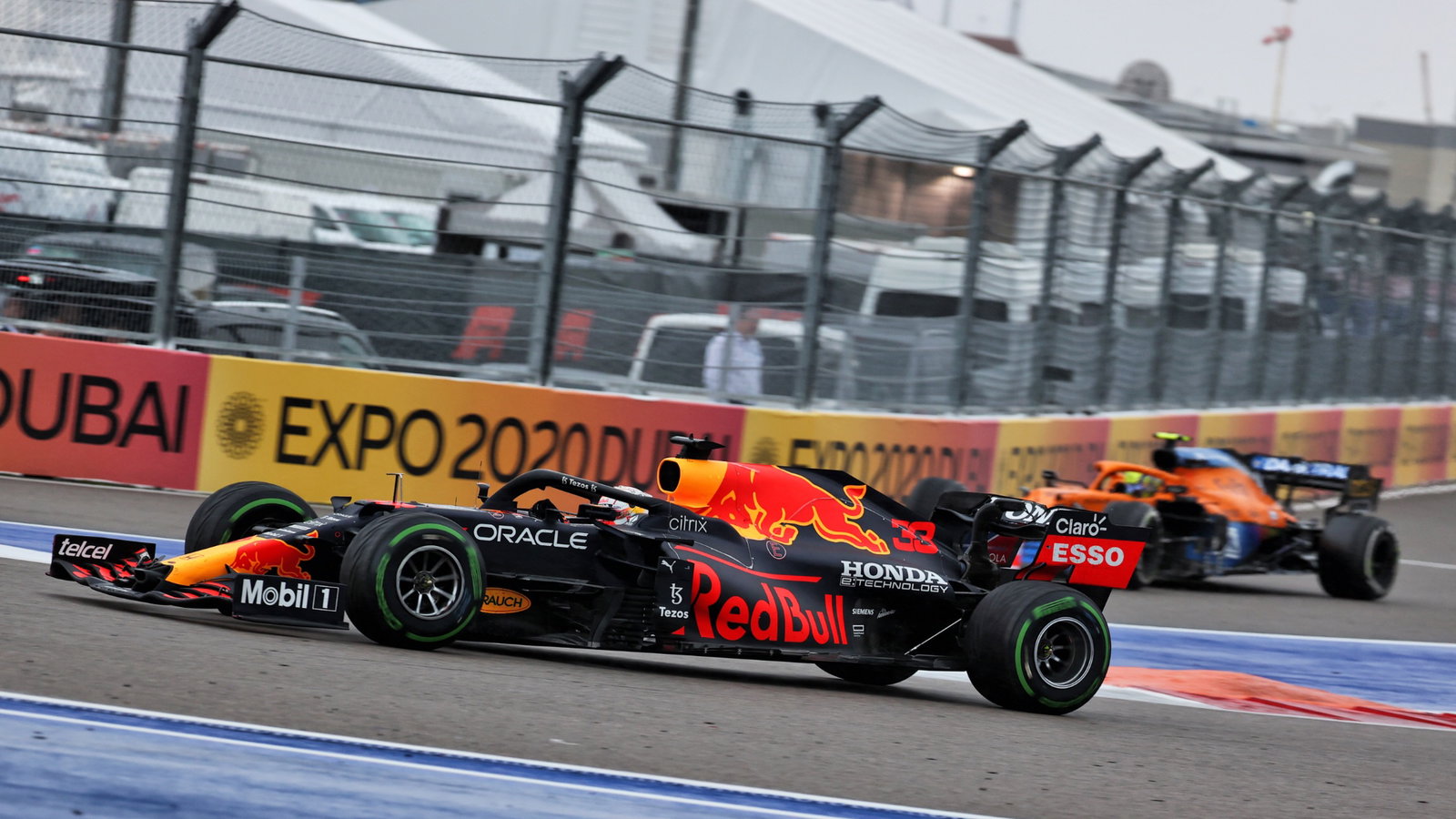 Lando Norris (GBR) McLaren MCL35M heads into the pits as Max Verstappen (NLD) Red Bull Racing RB16B passes him.