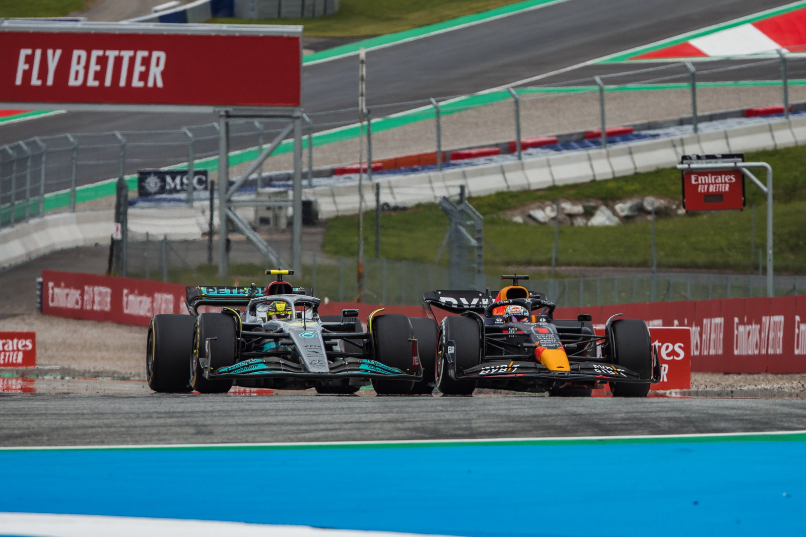 Lewis Hamilton (GBR) Mercedes AMG F1 W13 dan Max Verstappen (NLD) Red Bull Racing RB18 memperebutkan posisi. Formula 1