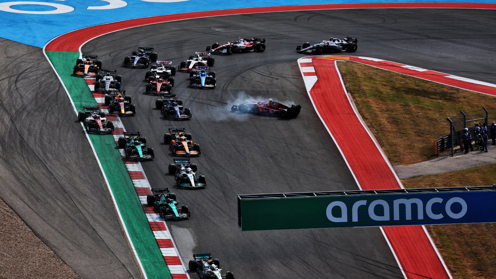 Max Verstappen (NLD) Red Bull Racing RB18 leads at the start of the race as Carlos Sainz Jr (ESP) Ferrari F1-75 is hit out