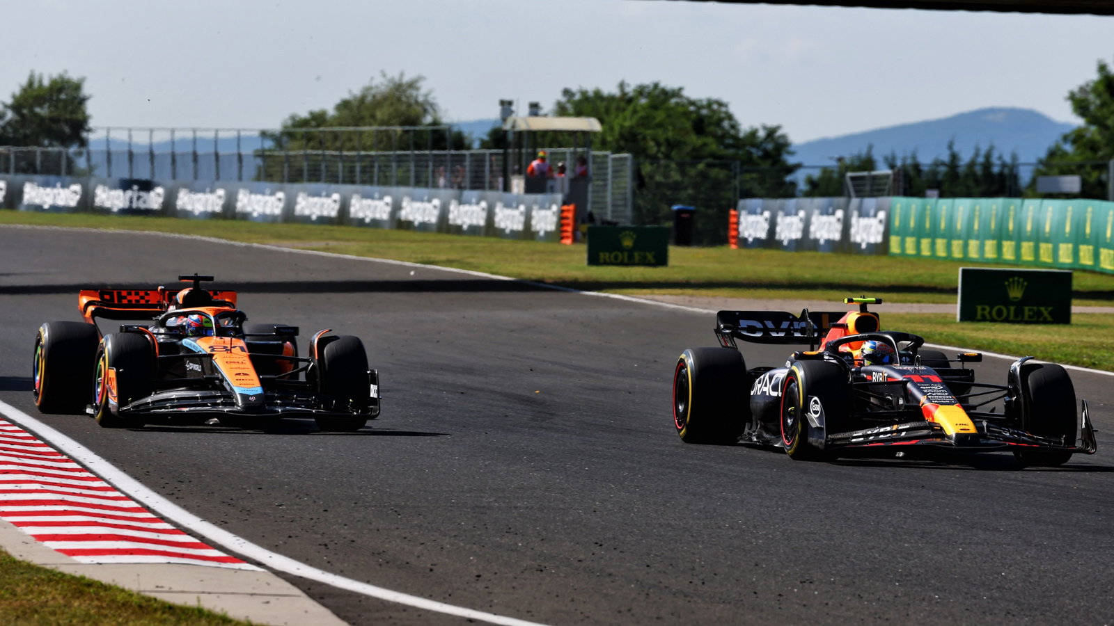 Oscar Piastri (AUS) McLaren MCL60 and Sergio Perez (MEX) Red Bull Racing RB19 battle for position. Formula 1 World