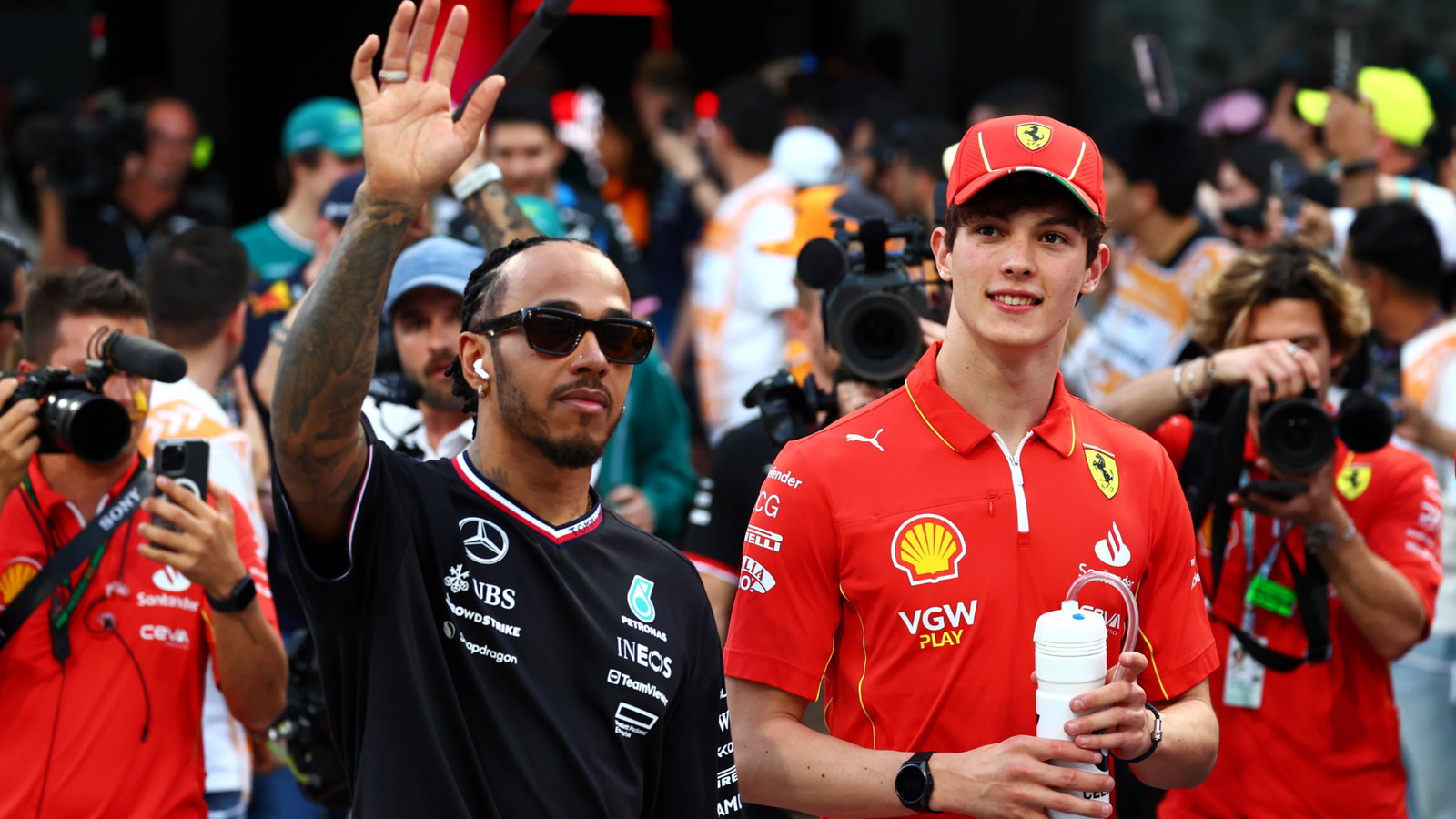 (L to R): Lewis Hamilton (GBR) Mercedes AMG F1 and Oliver Bearman (GBR) Ferrari Reserve Driver on the drivers' parade.