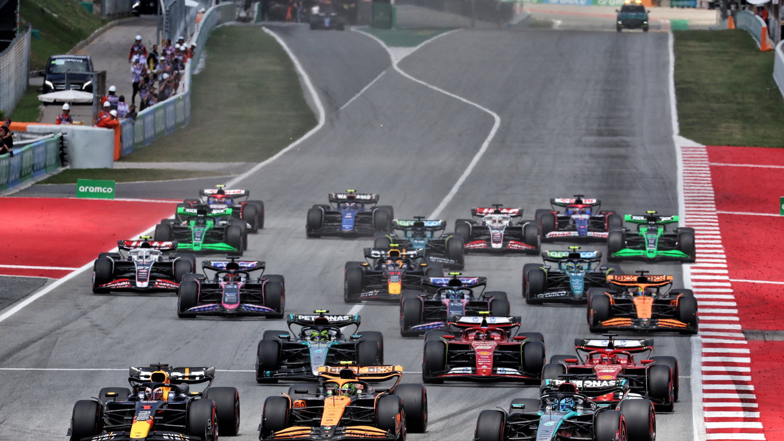 George Russell (GBR) Mercedes AMG F1 W15 leads Lando Norris (GBR) McLaren MCL38 and Max Verstappen (NLD) Red Bull Racing